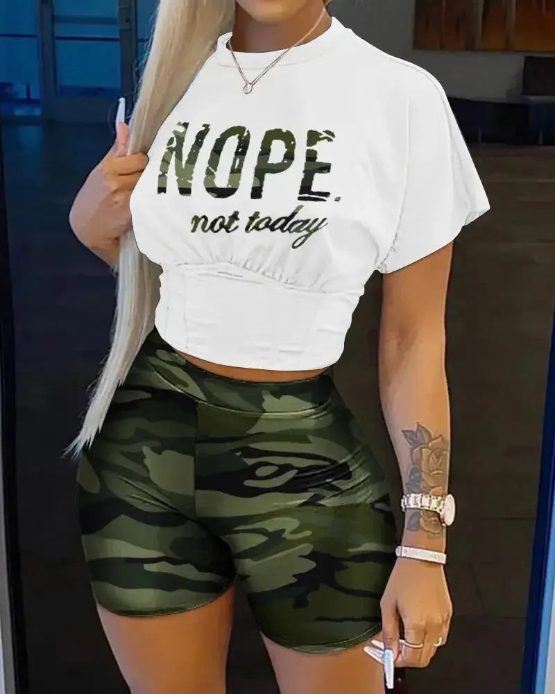 Person wearing a white crop top with 'NOPE not today' text and green camouflage shorts.