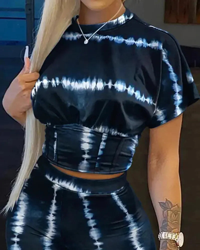 Person wearing a black and white tie-dye outfit with a blurred background