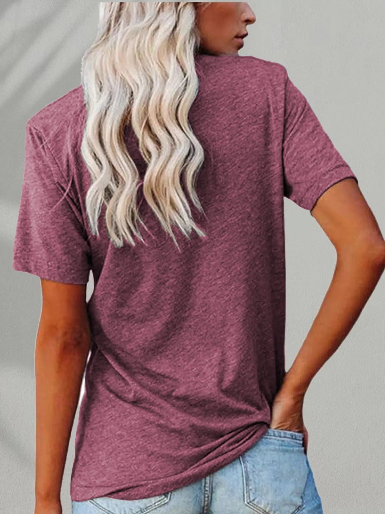 Person wearing a maroon t-shirt with a neutral background