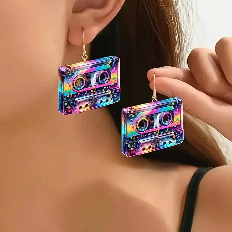 Colorful cassette tape-shaped earrings worn by a person
