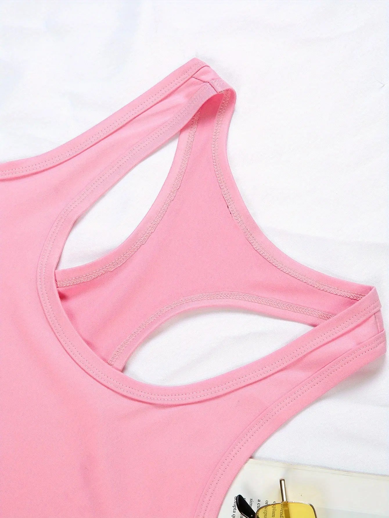 Detail shot of the Fantascticz 80s style tank top in light pink, showing the quality stitching and expert construction of the racerback design.