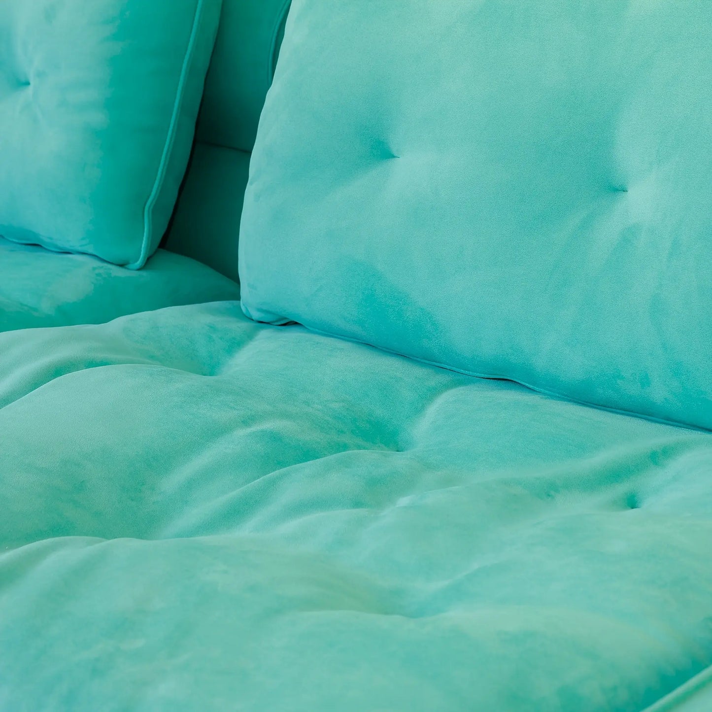 Close-up of teal bedding with pillows on a bed