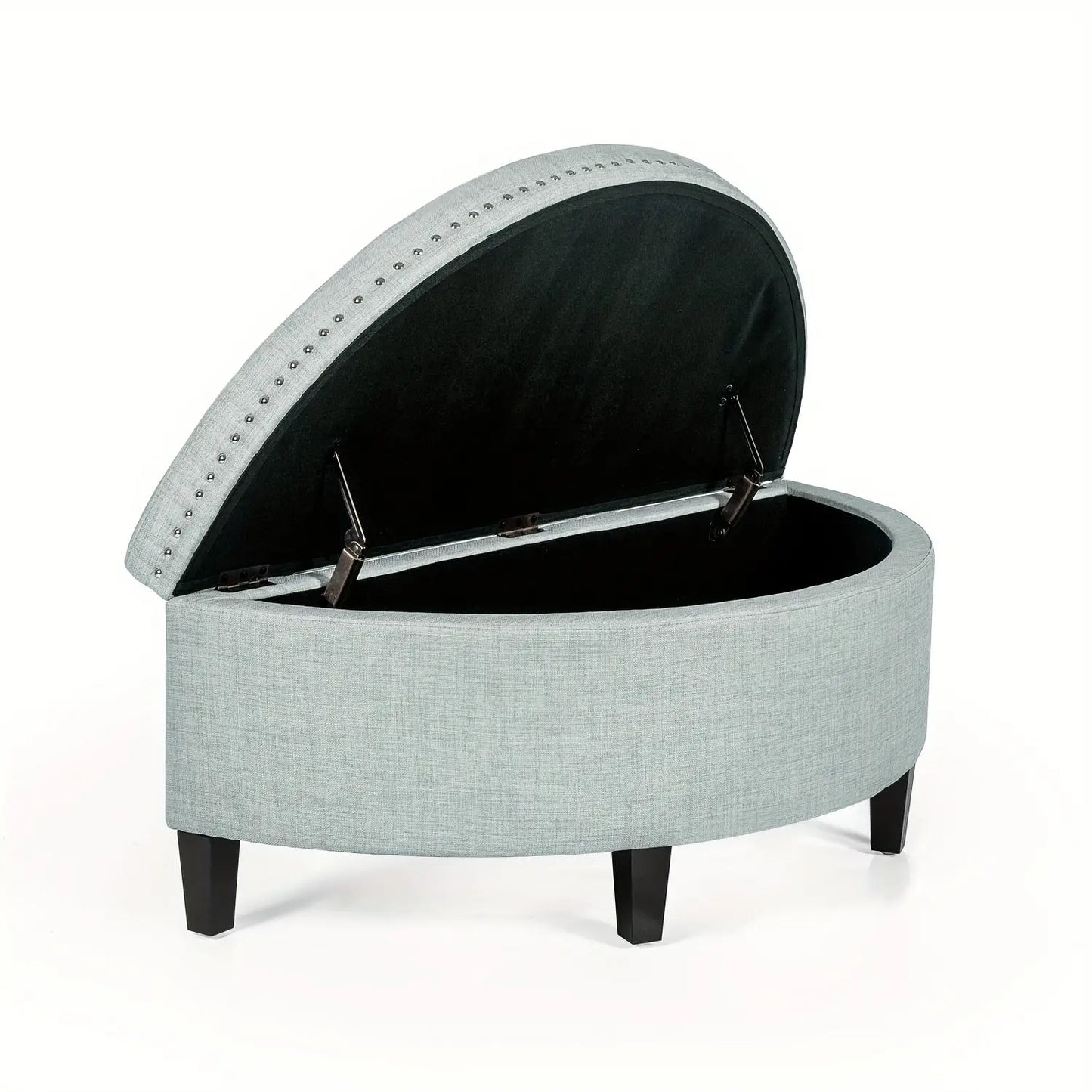 The Rhythm Storage Ottoman by Fantascticz in a sophisticated gray fabric, shown with its lid propped open by a safety hinge to reveal a spacious, black-lined interior for storage. The elegant silver nailhead trim adds a refined final touch.