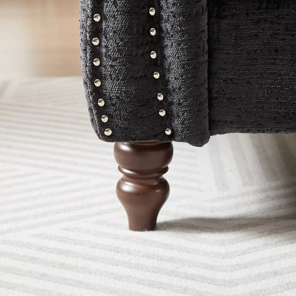 Close-up of a wooden bed post with studded detailing on a bed.