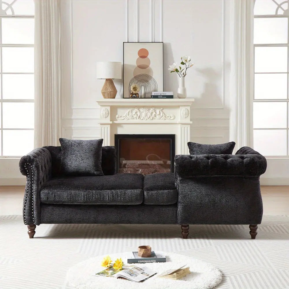 Dark gray sofa in a living room with a fireplace and decorative items.
