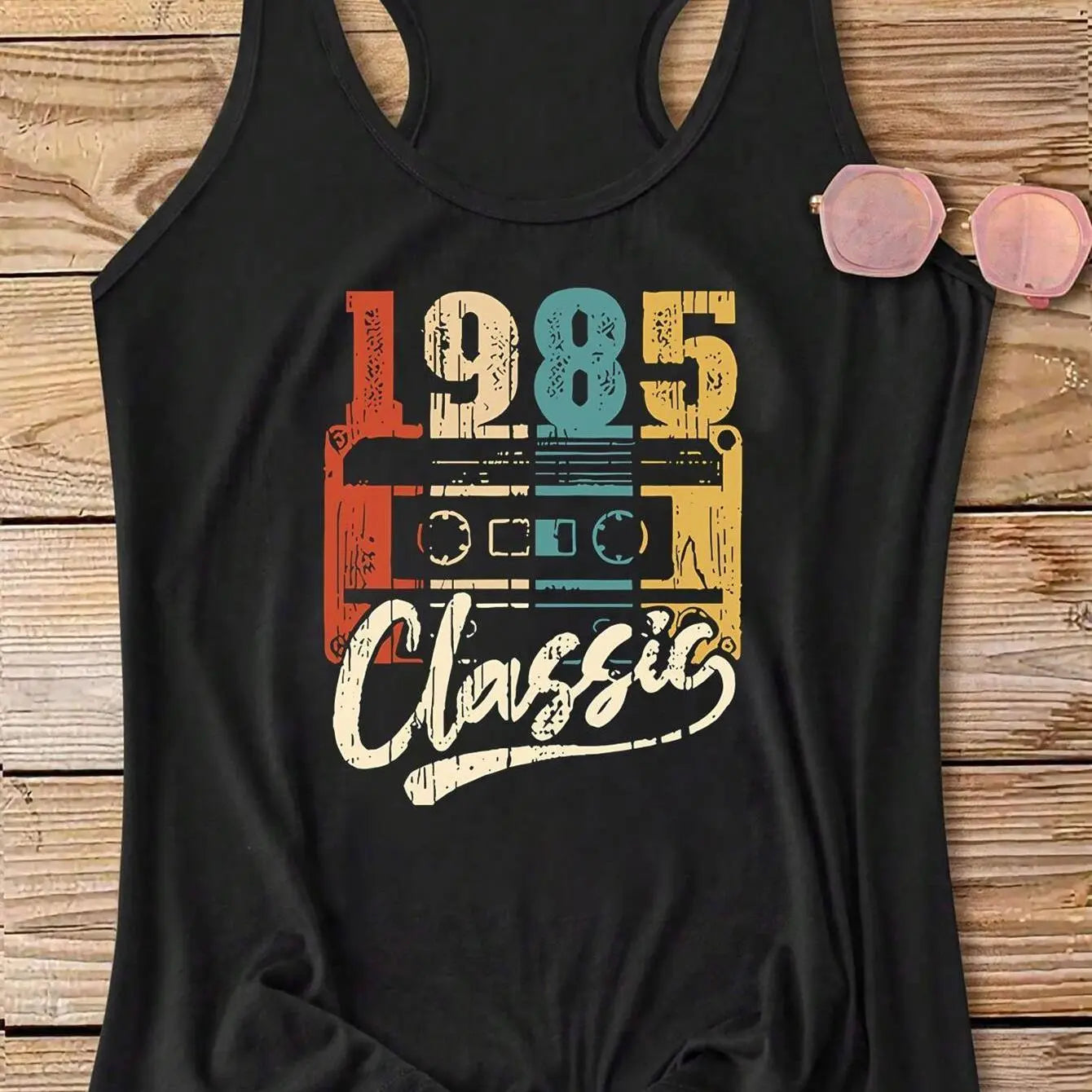 Styled shot of the black 1985 Classic Tank on a wooden surface, with sunglasses.