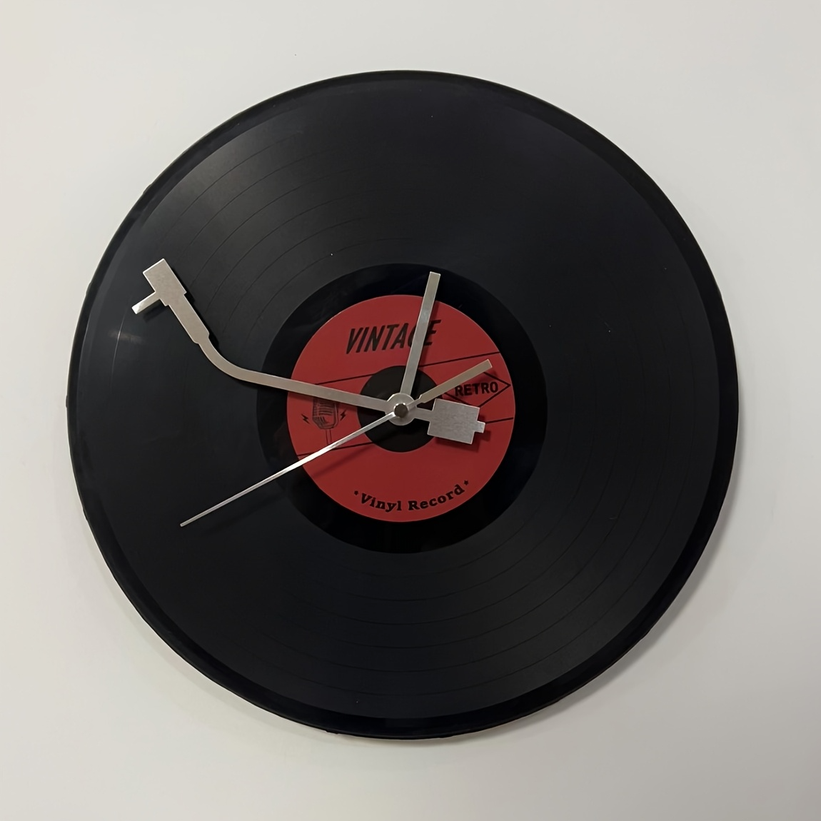 Wall clock made from a vinyl record with a red label on a white background
