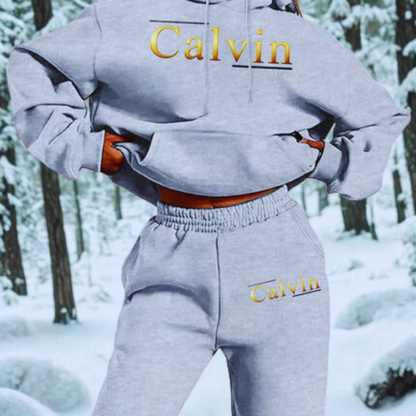 Person wearing a Calvin Klein hoodie and pants in a snowy forest