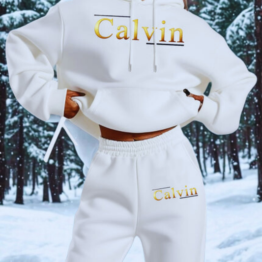 Person wearing a white 'Calvin' hoodie and pants in a snowy forest