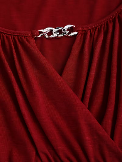 Close-up of a red garment with a silver chain detail.