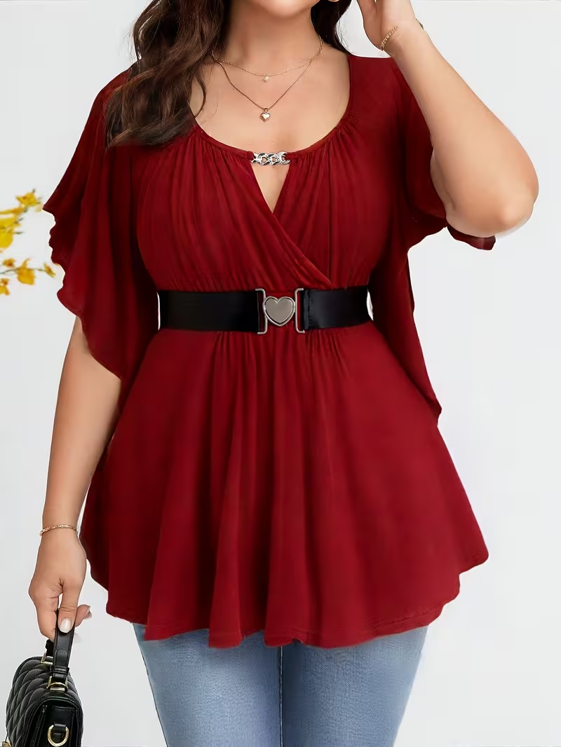 Red blouse with a belt worn by a person on a white background