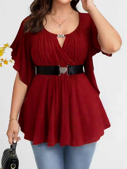 Red blouse with a belt worn by a person on a white background