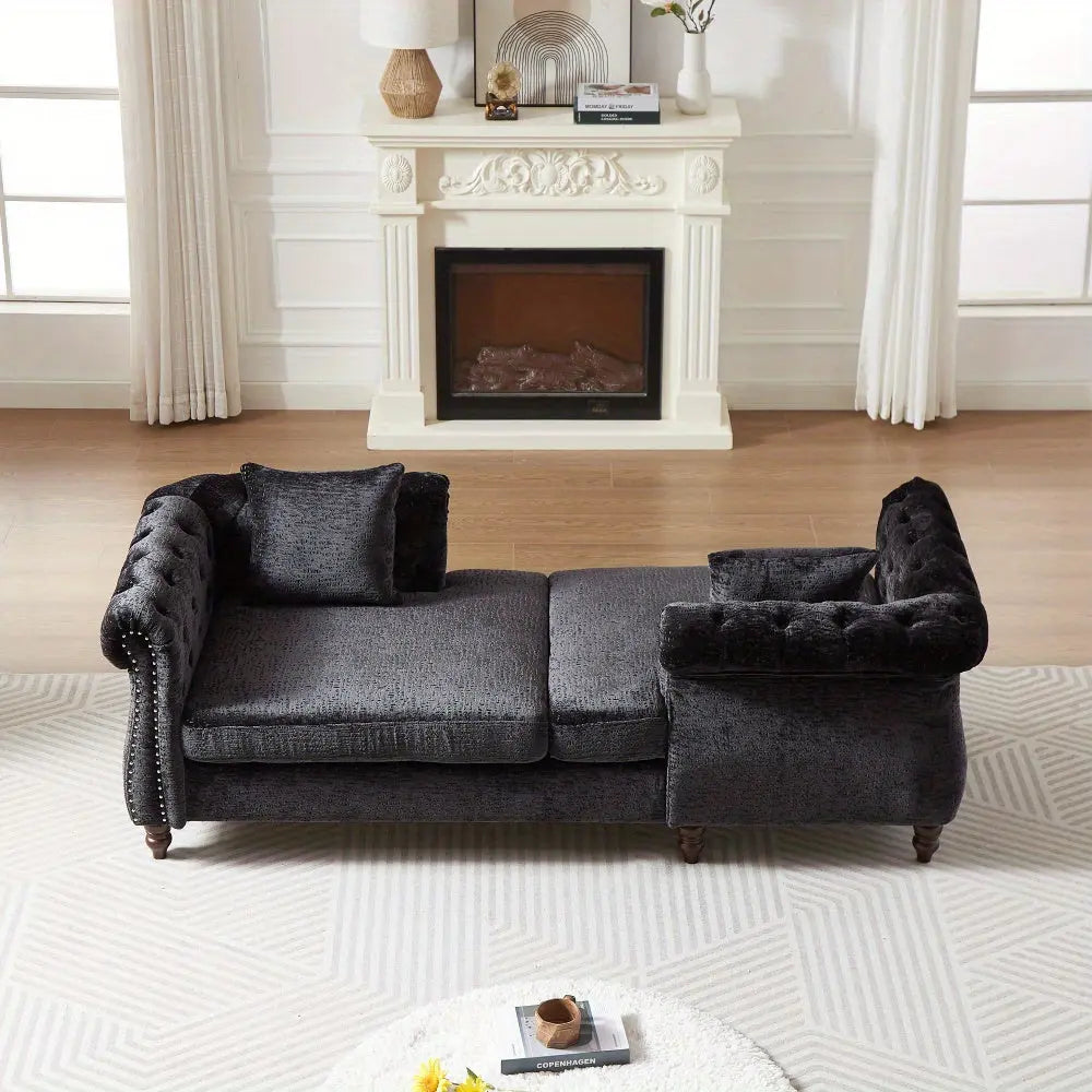 Black sectional sofa in a living room with a fireplace and decorative items.