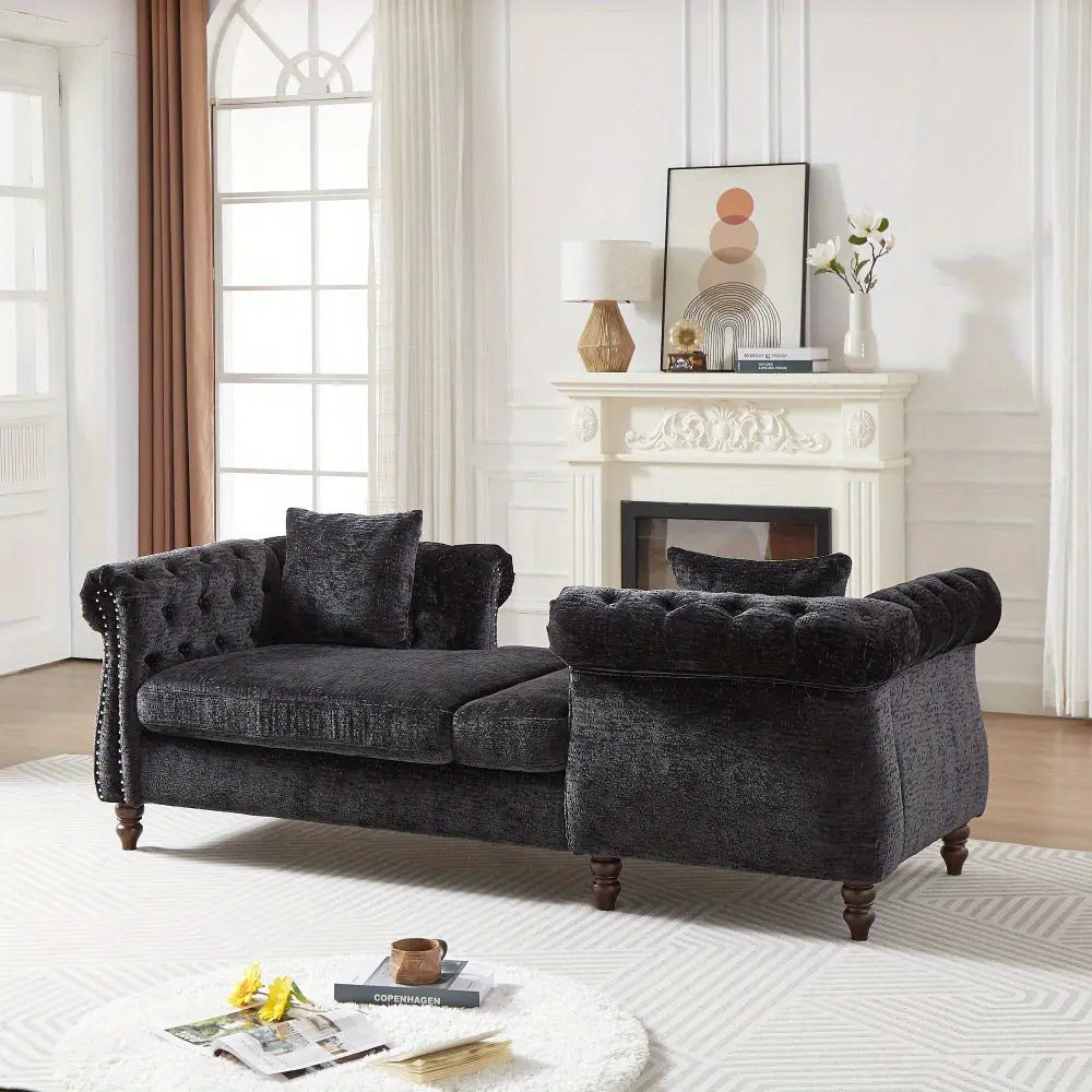 Black sofa in a living room with a fireplace and decor items.
