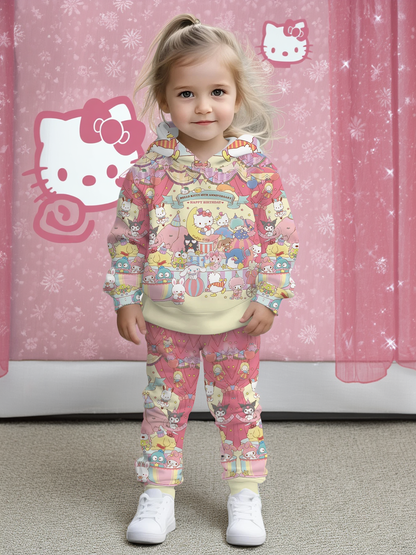 Child wearing a Hello Kitty-themed outfit in front of a pink curtain with Hello Kitty logos.