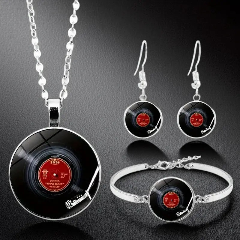 Jewelry set with vinyl record design necklace, earrings, and bracelet on a dark background