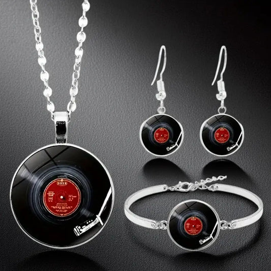 Jewelry set with vinyl record design necklace, earrings, and bracelet on a dark background