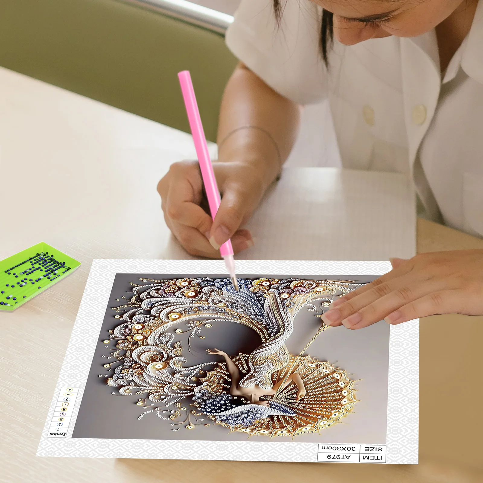 Person coloring a detailed design on a card with a pink pen