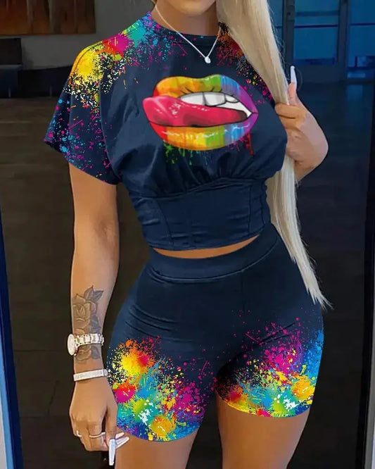 Woman wearing a black athletic outfit with colorful designs, including a rainbow-colored mouth graphic.