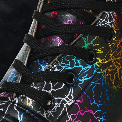 Close-up of a shoe with colorful abstract pattern and black laces on a dark background