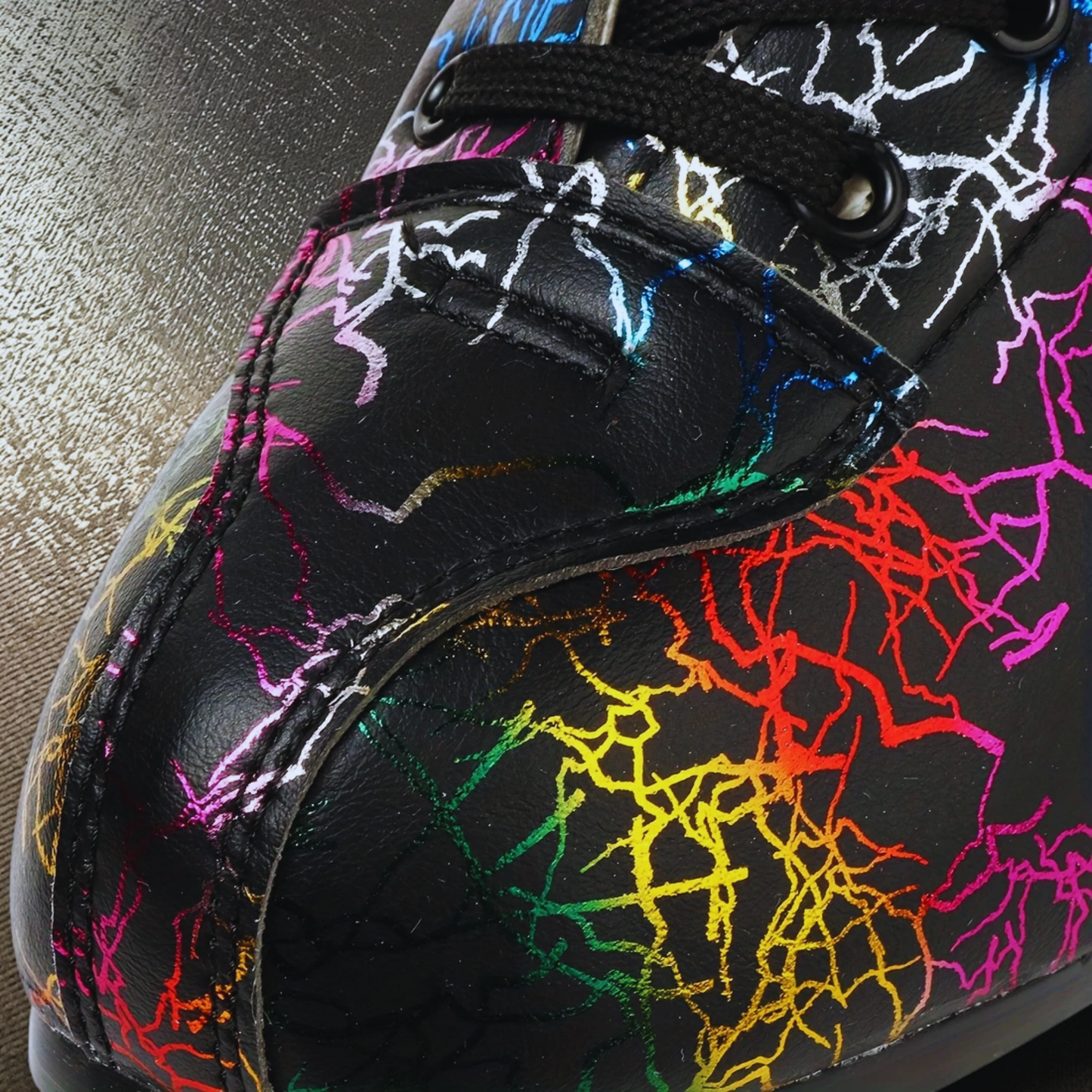 Close-up of a shoe with colorful abstract pattern on a metallic surface