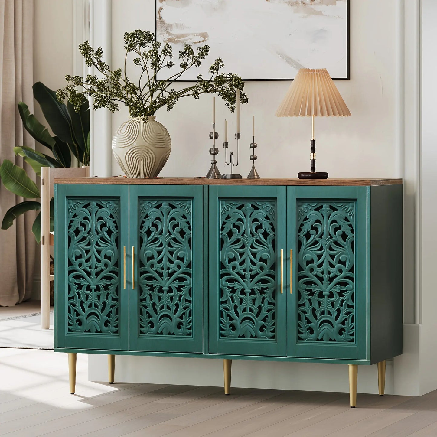 Teal cabinet with decorative carvings in a room with plants and a lamp.