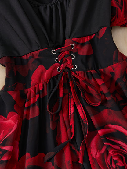 Black dress with red floral pattern and lace-up front on a mannequin.