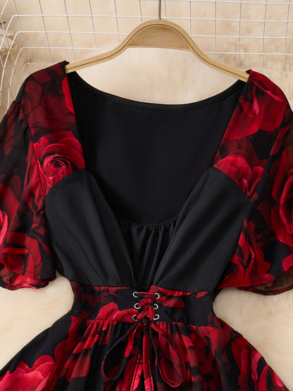 Black dress with red floral sleeves on a hanger against a tiled wall.