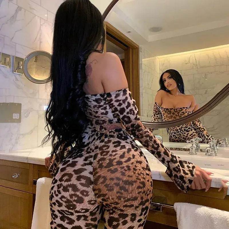 Woman in leopard print outfit looking at herself in the mirror in a bathroom.