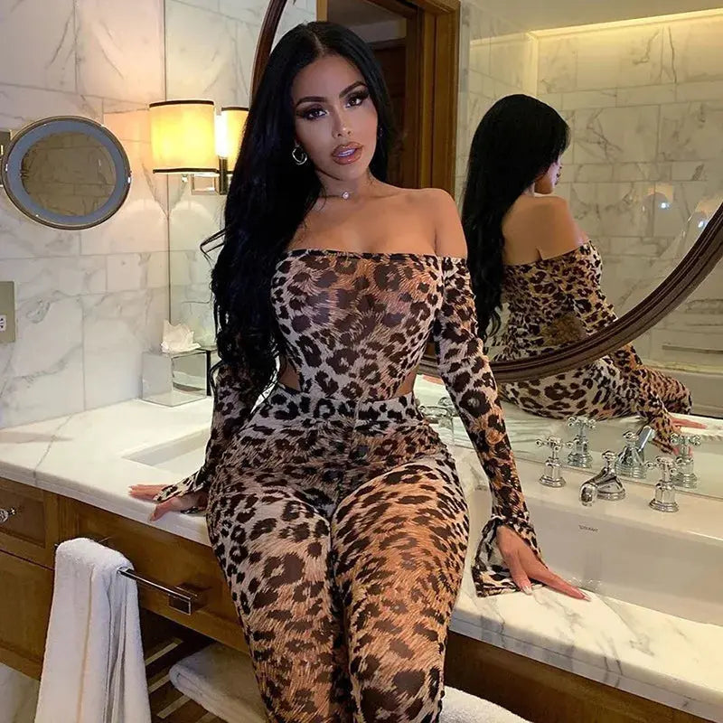 Woman in leopard print outfit sitting on a bathroom counter.