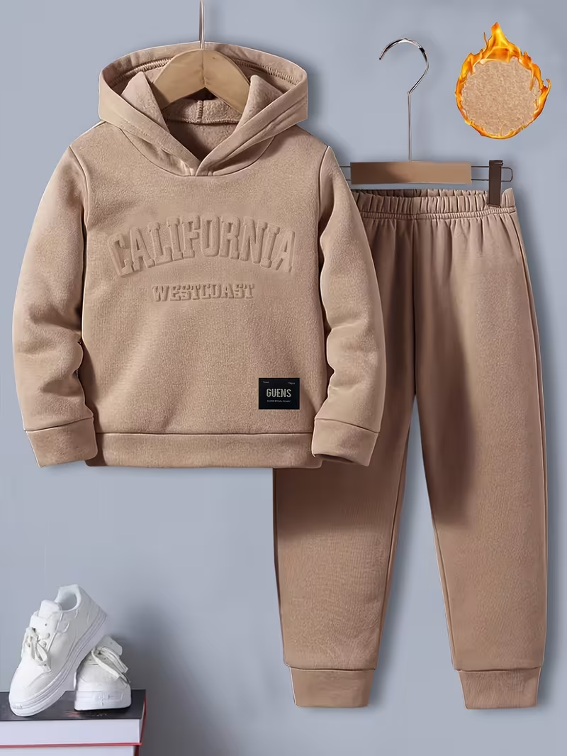 A child’s tan fleece-lined sweatsuit, including a hoodie and pants. The hoodie has ‘CALIFORNIA WESTCOAST’ embossed on the chest, and an icon highlights the warm, fleecy interior lining.