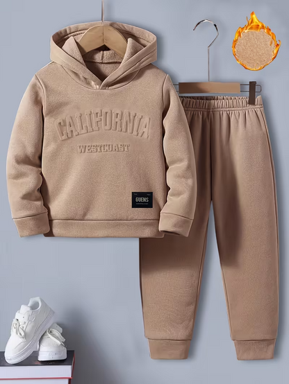 A child’s tan fleece-lined sweatsuit, including a hoodie and pants. The hoodie has ‘CALIFORNIA WESTCOAST’ embossed on the chest, and an icon highlights the warm, fleecy interior lining.