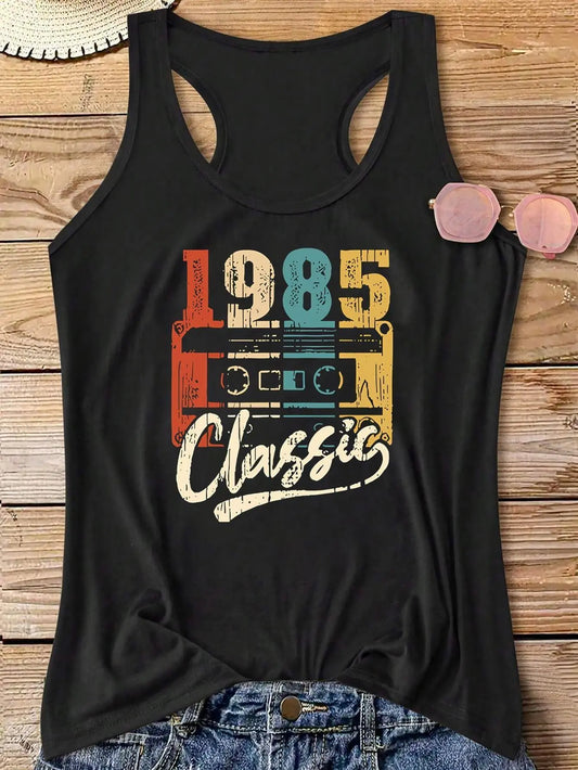 Styled photo of The 1985 Classic Tank, a black racer back tank top featuring a vibrant “1985 Classic” cassette deck graphic, styled with a denim skirt, sunglasses, and a straw hat for a retro summer look.