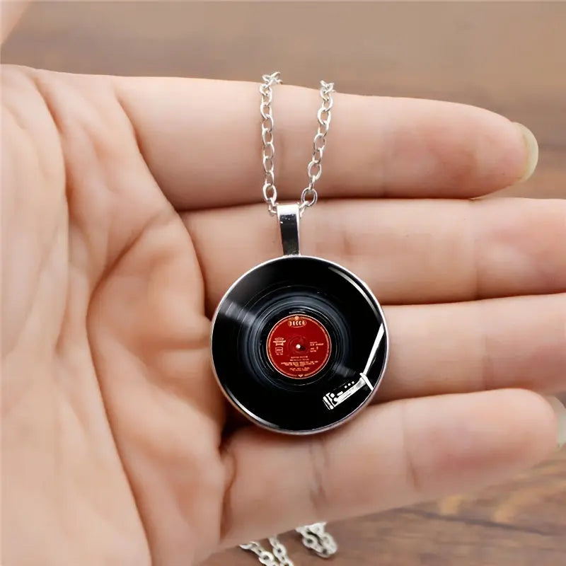 Record necklace held in a hand with a blurred background